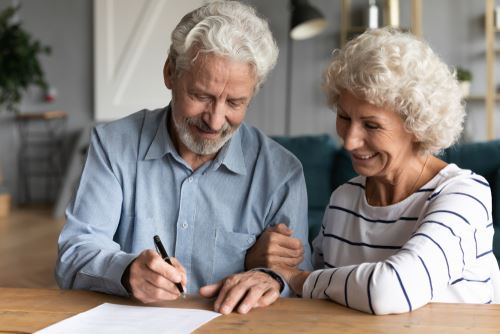 Elderly couple signing will in elder law firm in New York