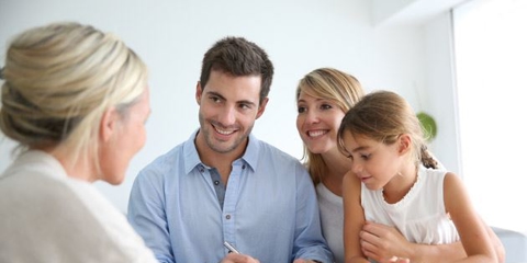 family smiling signing papers with kid