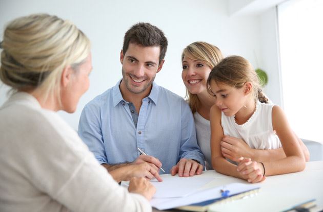 family smiling signing papers with kid